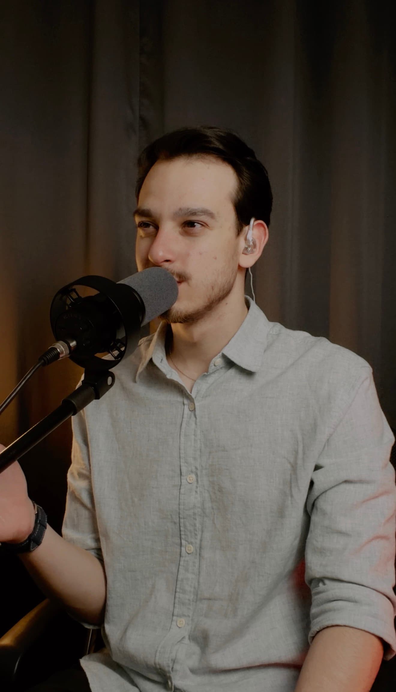 Pedro cantando ao microfone com retorno intra-auricular