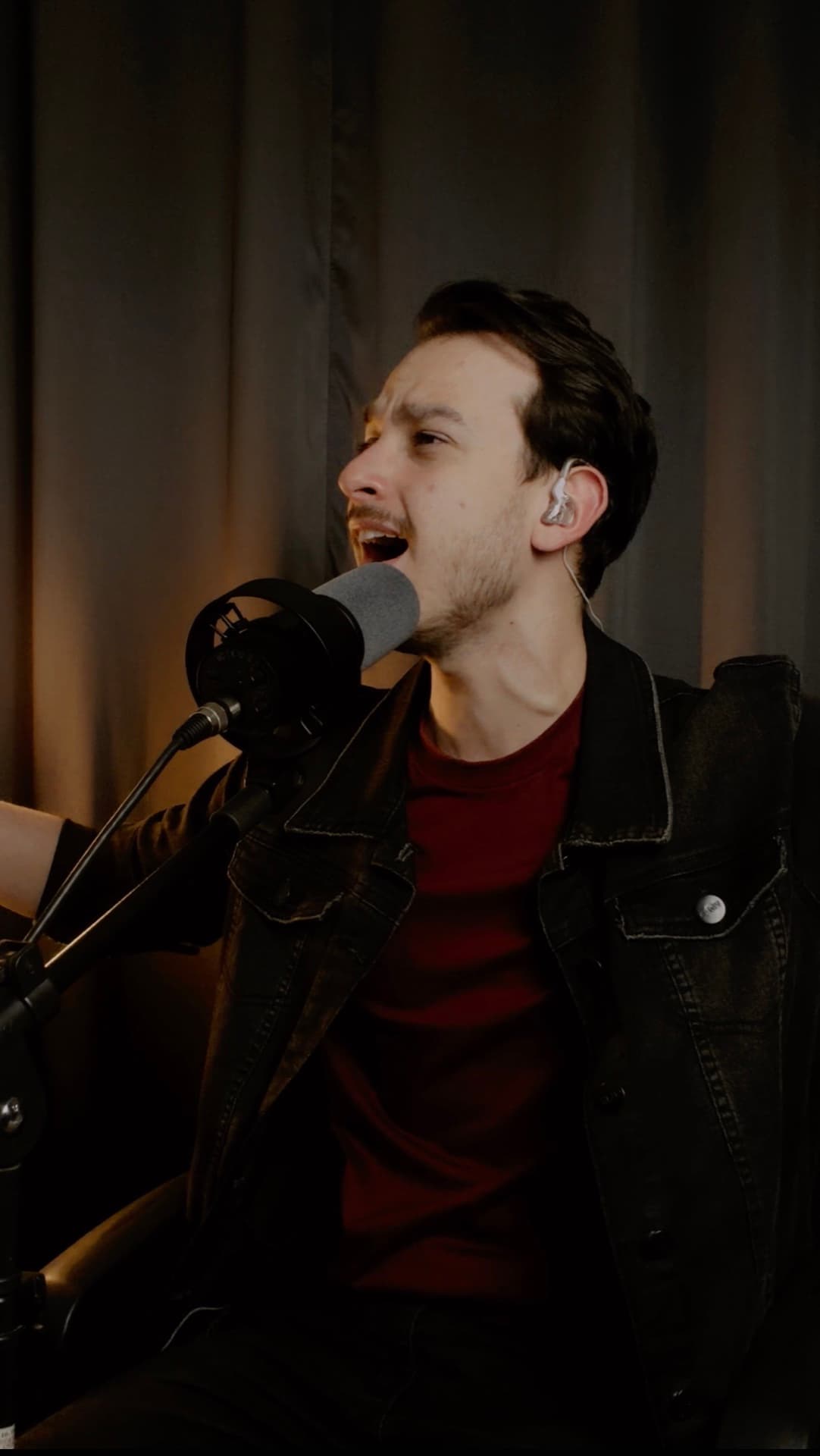 Pedro cantando ao microfone no estúdio
