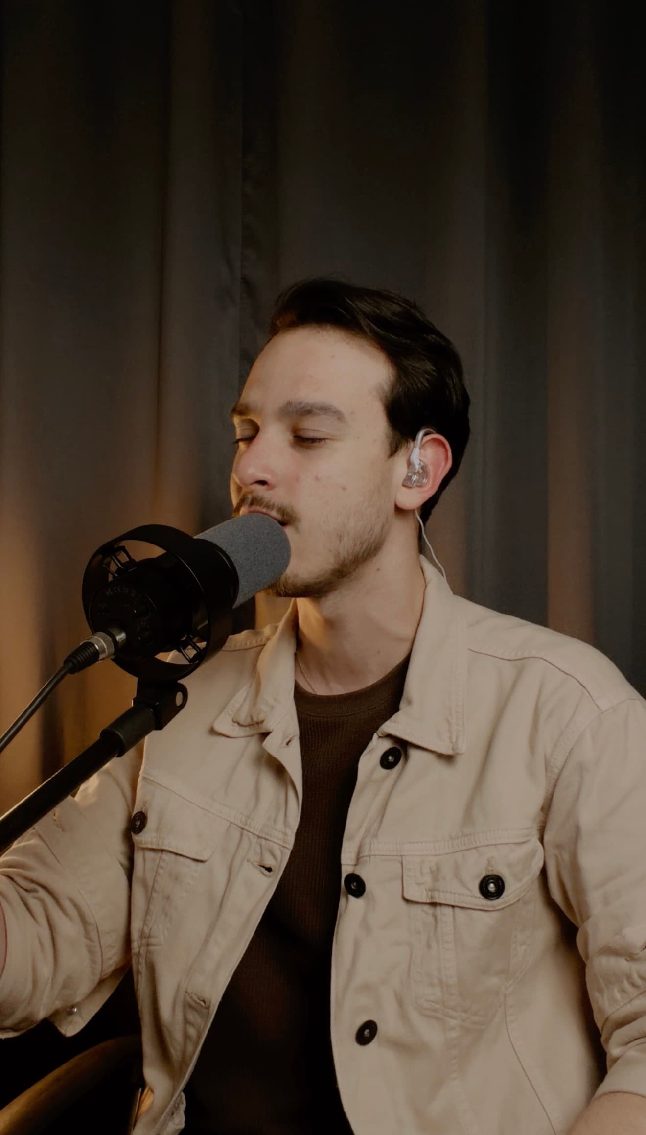 Pedro cantando ao microfone de olhos fechados
