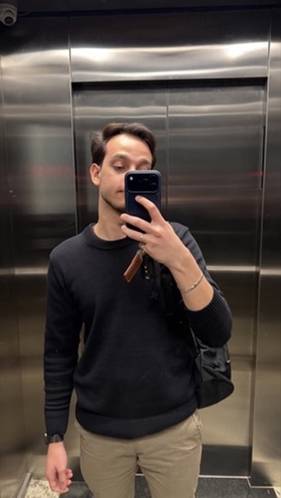 Pedro in the office elevator, backpack on