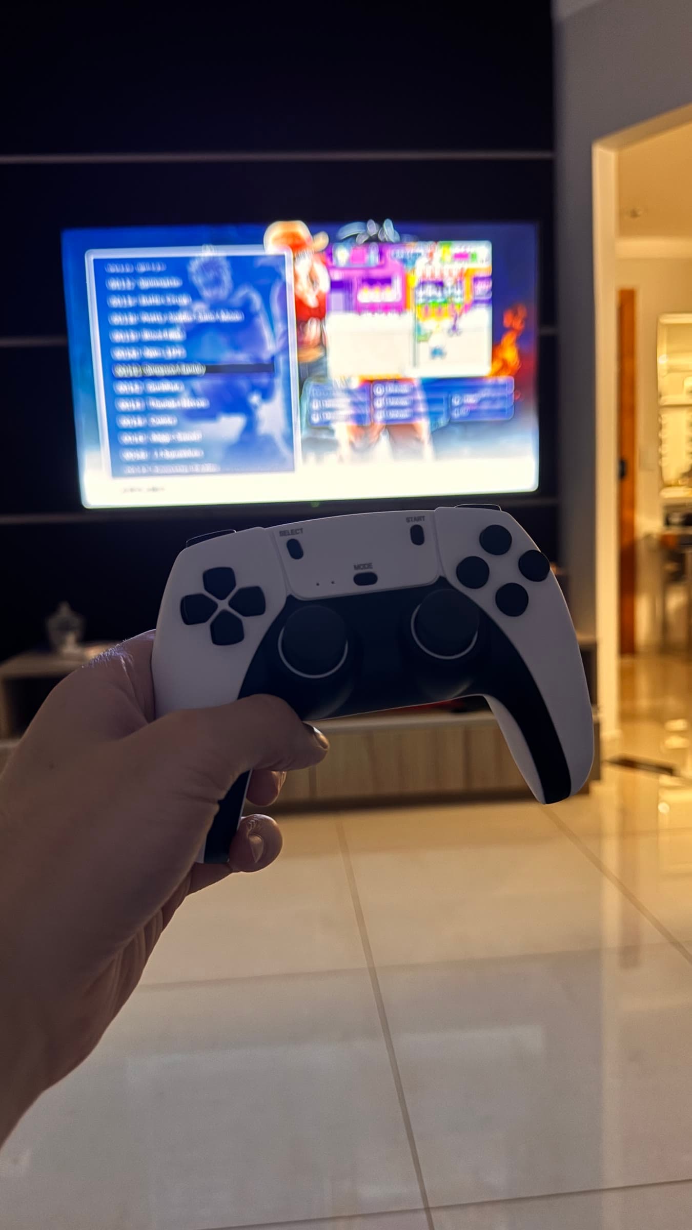 PlayStation controller held in front of a television